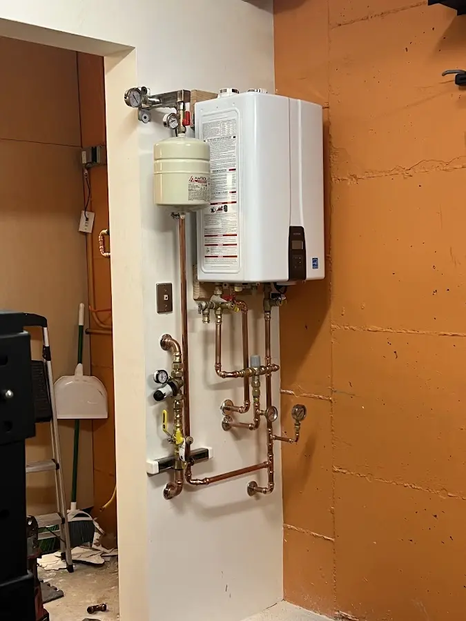 Plumbing technician inspecting water heater connections in Owasso